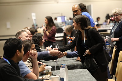 Attendees shaking hands in the Expo Hall