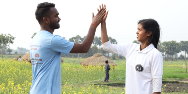 Teenagers from Bihar, India, high five in celebration of their work ending child marriage in their village.