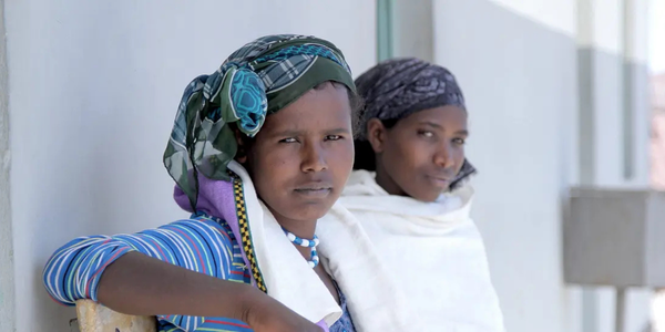 Two women look proudly at the camera.