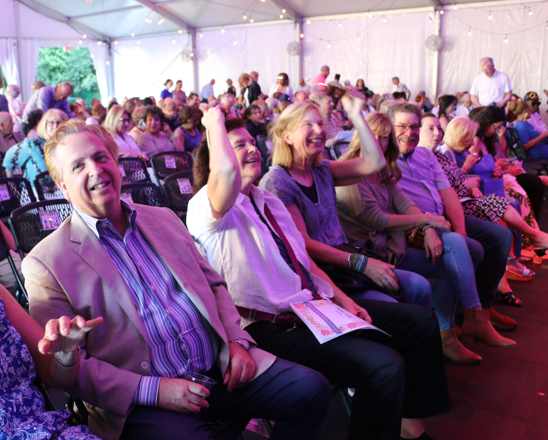 Festival patrons sitting and cheering in the seasonal pavilion.