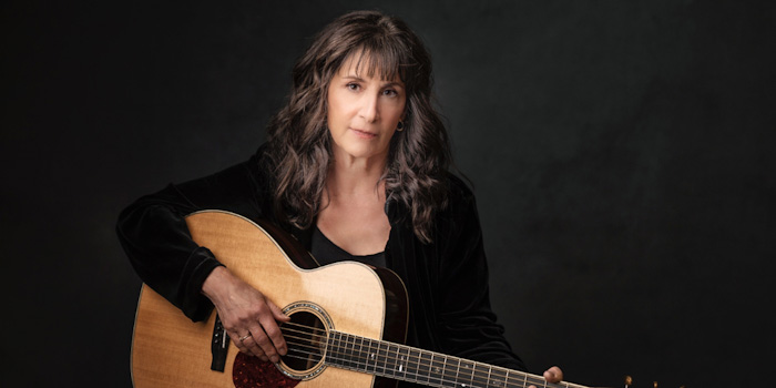 Photo: musician Karla Bonoff posed with an acoustic guitar