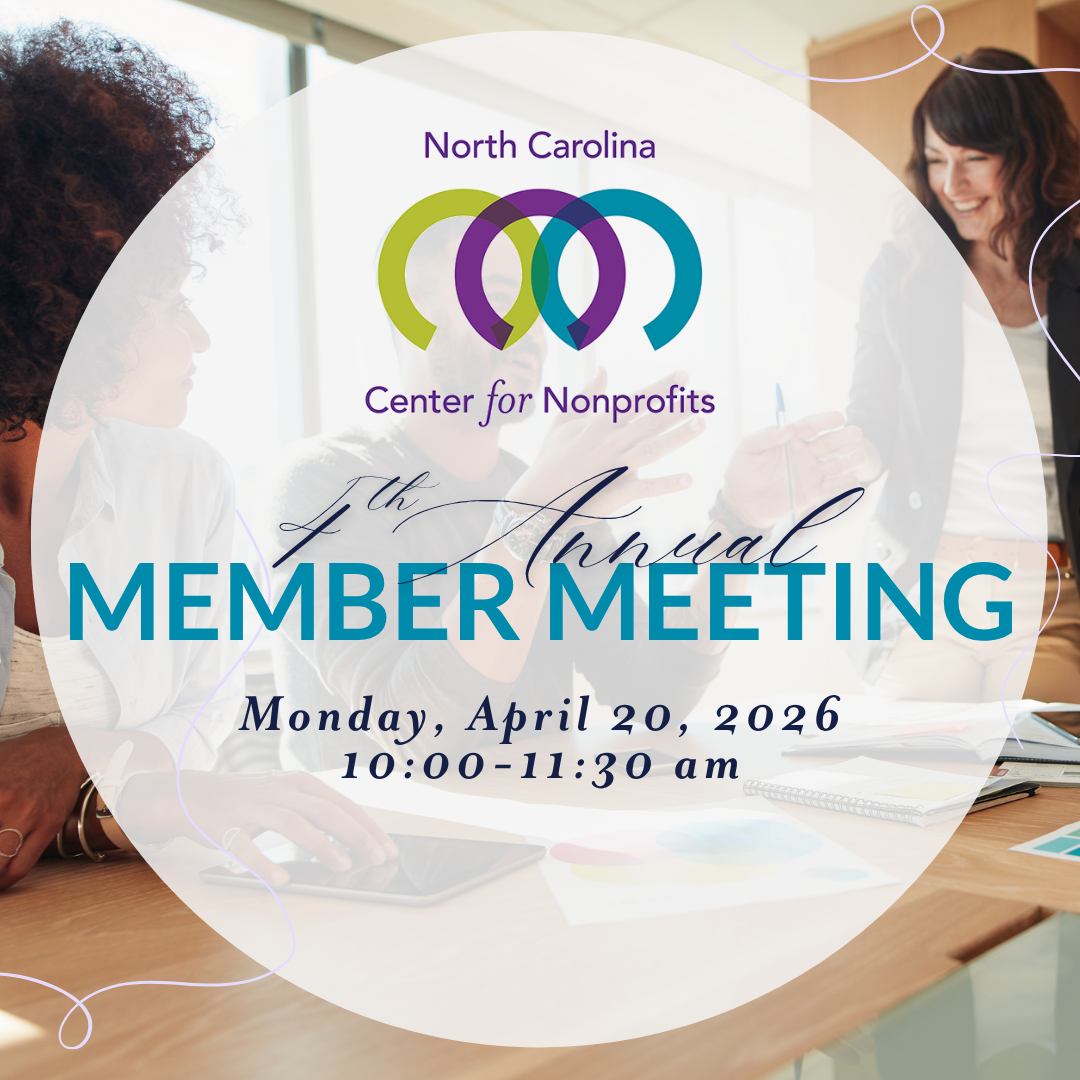 Several young professionals in an office setting talking and working together.