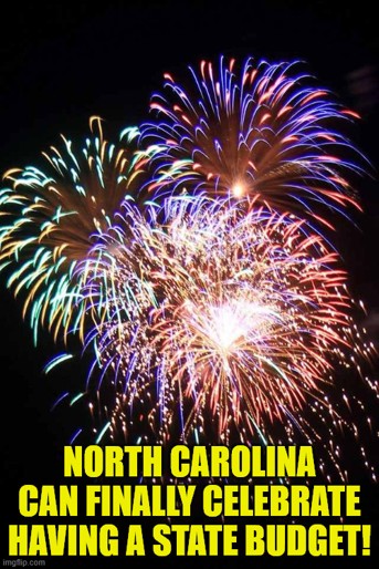 Meme with multi-colored fireworks spreading across the dark night sky. Text reads 'North Carolina can finally celebrate having a state budget!'