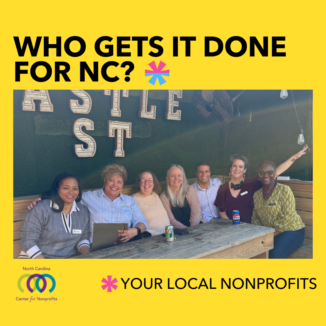 Photo of seven people sitting around a wooden farmhouse table, smiling and leaning into each other. Text reads 'Who gets it done for NC? Your local nonprofits.'