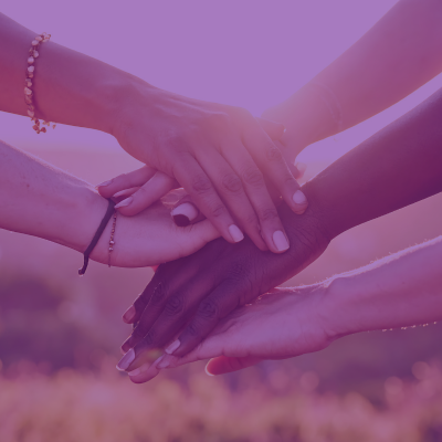 Four hands stacked on top of each other as if in cooperation.
